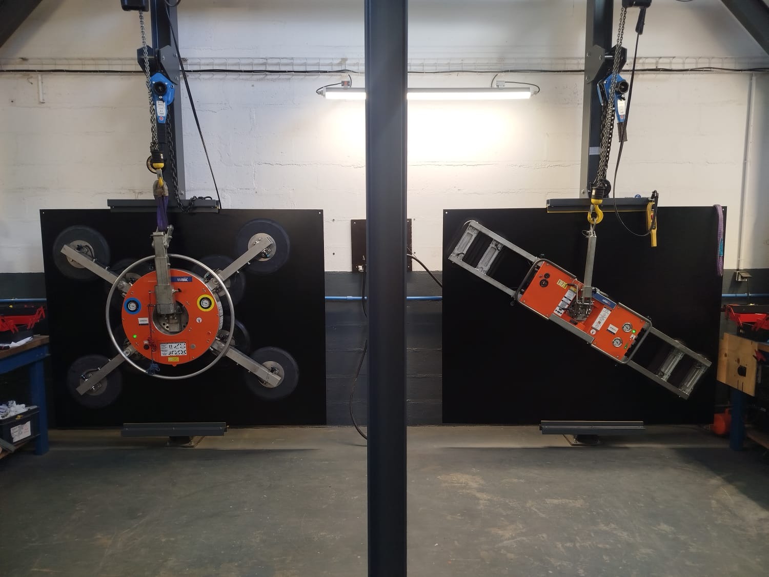 Deux palonniers à ventouse ViaVac en essai sur les plaques d'acier verticales de l'atelier CETEOVAC